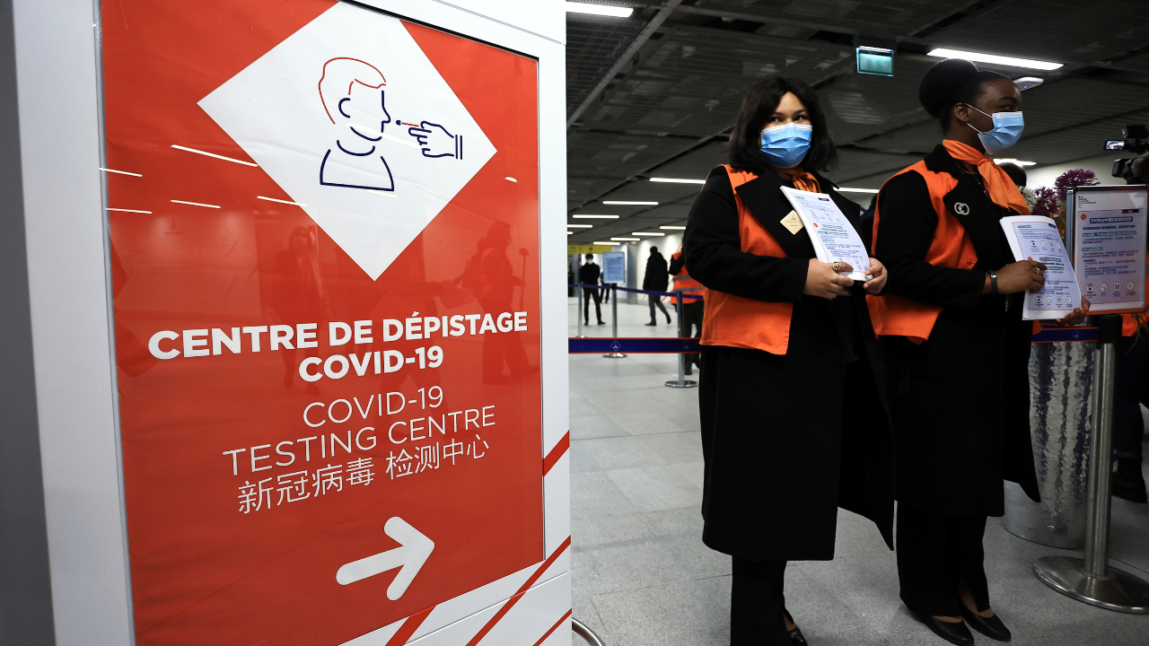 Airport staff wait from passengers coming from China in front of a COVID-19 testing area set at the Roissy Charles de Gaulle airport, north of Paris (AP)