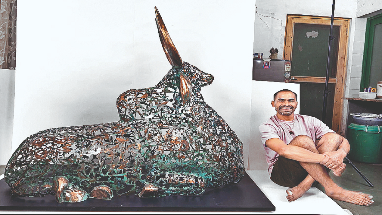 Artist Nilaoyy K Nandi with his sculpture