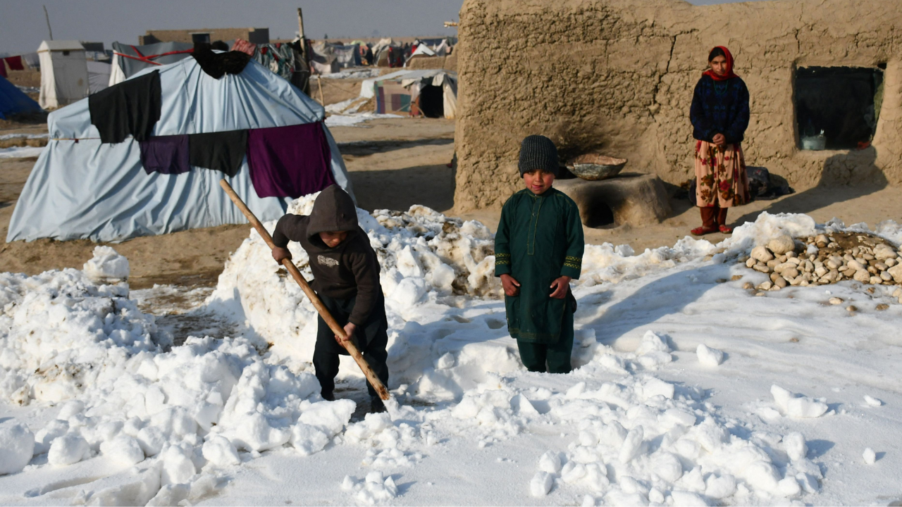 Afghan internally-displaced children shovel snow near their tents during a cold winter day at Nahr-e Shah-e- district of Balkh Province, near Mazar-i-Sharif (AFP)