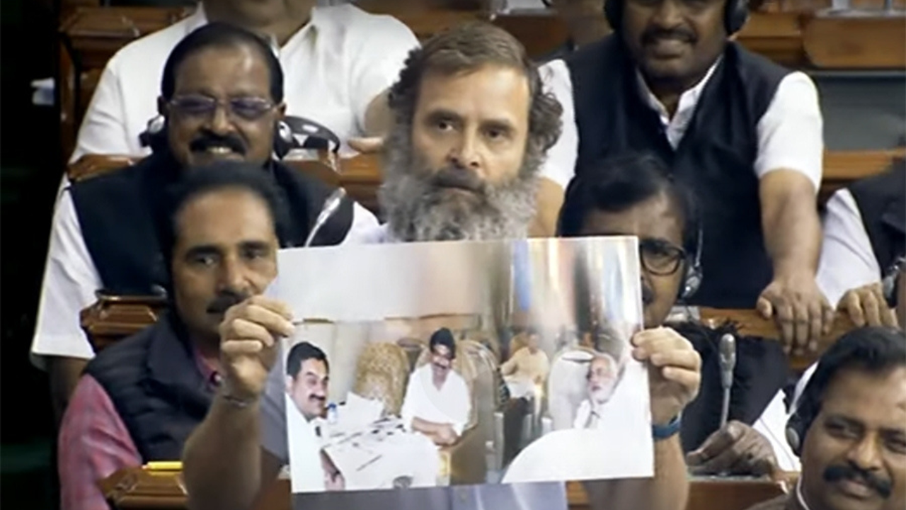 Congress MP Rahul Gandhi shows an old photo of PM Modi with industrialist Gautam Adani in Lok Sabha (IANS)