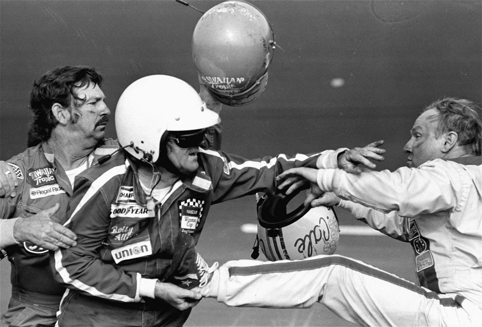FILE - Bobby Allison, center, holds race driver Cale Yarborough's foot after Yarborough, right, kicked him following the Daytona 500 auto race in Daytona Beach, Fla., Feb. 18, 1979. (AP Photo/Ric Feld, File)
