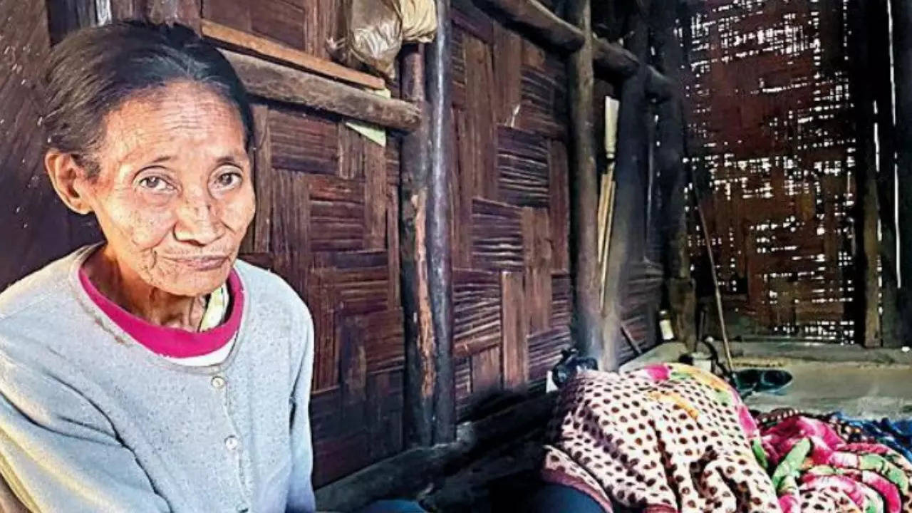 Septuagenarian Kamyin sits near her son, a survivor of the Oting incident, who is since then in a vegetative state, in Mon district