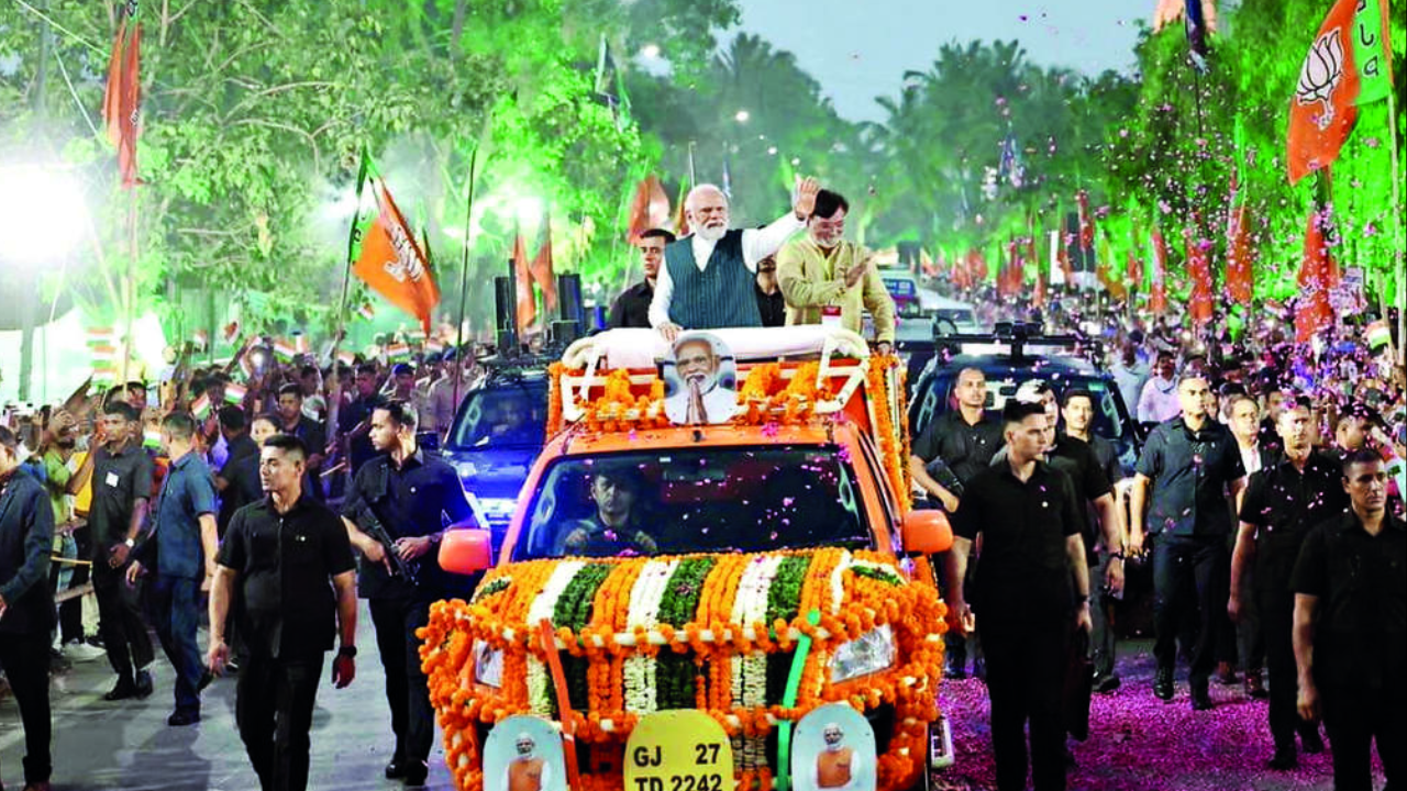 PM Modi greeting people during a 16 km roadshow in Daman