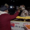Locals distribute sweets outside Silkyara tunnel as trapped workers are being rescued.