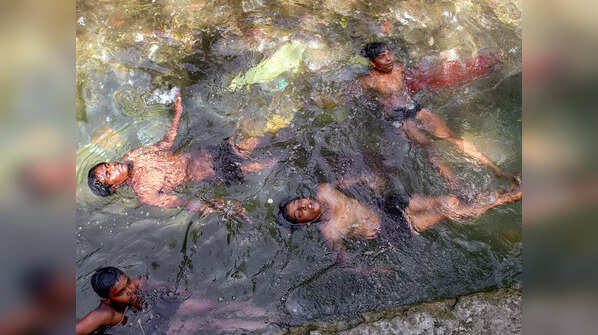 Children take bath to beat the heat
