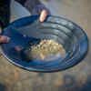 What is the method of searching for gold in rivers called?