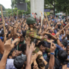 ​Protesters carry army member on shoulders
