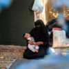 ​Woman holds child inside the camp