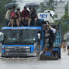 ​Commuters riding on top of a truck