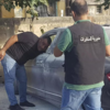 Officials examining a car