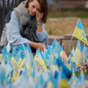 Woman cries at makeshift memorial place having Ukrainian flags