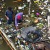 Tamil Nadu Rain Live: People walk through knee deep water filled with sewage and garbage at Pattalam in North Chennai.