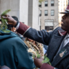 Doorman distributes tree branches at Rockefeller center