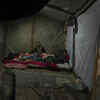 Article image for: Displaced from northern Gaza, woman huddles with children for warmth