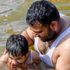 A Father helping his child with the Kumbh Snan
