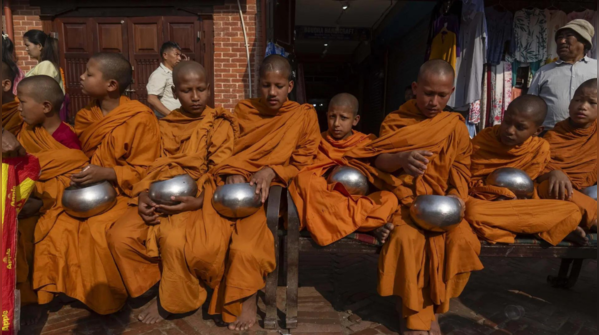 Young monks receive alms on Buddha jayanti in Kathmandu