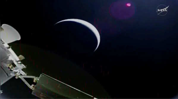 Earth’s crescent is seen from a solar array camera on the Orion spacecraft on the first flight day of the Artemis II mission.