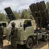 Article image for: Hezbollah fighters in front of multiple-barrel rocket launchers (AP)