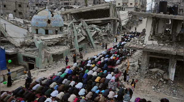 People offering prayers amidst ruins