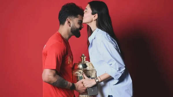 Anushka Sharma poses with Virat Kohli and the IPL trophy