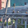 Workers focus on roofing section of elevated metro corridor