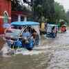 Vehicles ply through a waterlogged road after heavy rains at Balurghat in South Dinajpur district of West Bengal on Sunday.