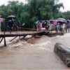 Locals try to repair the Balu Khola bridge at Nagrakata of Jalpaiguri district of West Bengal on Saturday after heavy rains in the region. PTI Photo