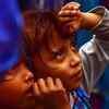 Children looks at devotees forming a human pyramid during celebrations to mark the festival of Janmashtami in Mumbai.