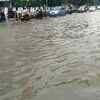 Commuters wade through flooded streets in city area