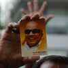 A DMK supporter holding a photo of M Karunanidhi outside the Kauvery hospital in Chennai