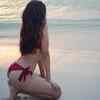 Showing off her stunning back in a bold red bikini