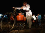 People carrying water container on bicycles