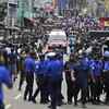 Sri Lankan police officers clear the road as an ambulance drives through carrying injured of Church blasts in Colombo.