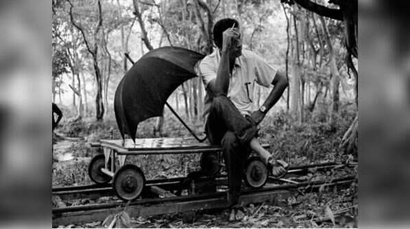 Ray sitting on a trolley during the filming of 'Asani Sanket'