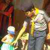 Scout and guides volunteers take care of toddlers as their mothers cast vote, at a polling station in Sonarpur, Varanasi