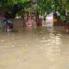People walk through flooded street amid heavy downpour in Mumbai
