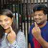 Voters show their inked finger after voting in Mumbai