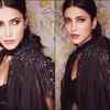 Shows off her toned figure and washboard abs in a black outfit