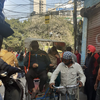A woman turns up with oxygen cylinder to cast her vote at a polling booth in Laxmi Nagar.
