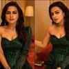 Steals the show in a sequin one-shoulder dress with long earrings and statement bracelet