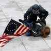 A police officer detains a pro-Trump protester as mobs storm the US Capitol