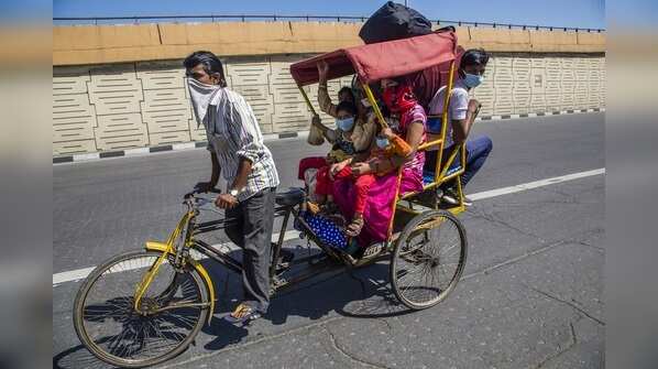 Migrant workers wait to board buses to return to their villages in Ghaziabad on March 28, 2020.