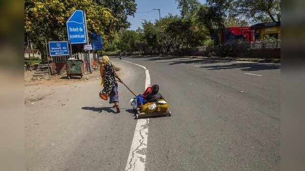 A migrant worker pulls her relative walking back to her native home in Delhi on March 28, 2020.