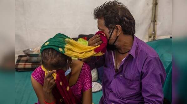 A couple from Jhansi wipe away their tears as they wait to get a date for chemotheraphy on April 01, 2020 in New Delhi.