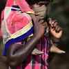 Migrant workers carry their belongings as they walk along a road to return to their villages on April 01, 2020.