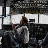Taliban fighters sit in the cockpit of an Afghan Air Force aircraft at the airport in Kabul