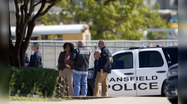 Law enforcement officers gather in the parking lot of Timberview High School after the shooting inside Wednesday.