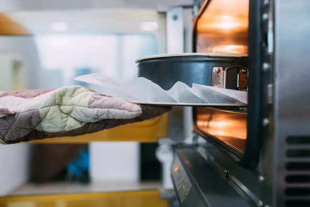 cropped-image-of-a-hand-putting-container-with-cake-in-oven-picture-id1268482949 (1)