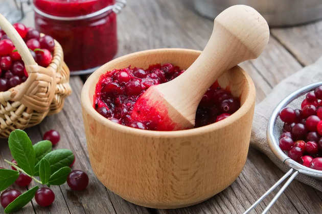 wooden-bowl-of-crushed-cranberries-basket-of-bog-berries-jar-of-jam-picture-id1188274328