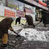 Locals clear the snow from the road in Shimla